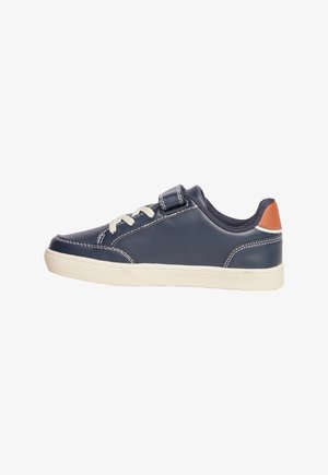 Sneaker in pelle blu navy con lacci elastici, fascia in Velcro e suola in gomma color crema. Presenta cuciture bianche e un accento in pelle marrone sul tallone.