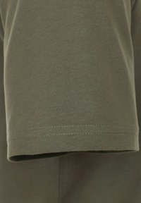 Olive zielony bawełnowy T-shirt z rękawem, o gładkiej fakturze i prostym dołem z dyskretnym podwójnym szwem.