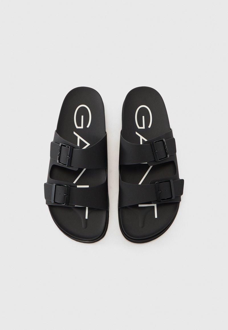 Czarne sandały wykonane z trwałego materiału, z dwiema regulowanymi paskami, posiadające zapięcie w postaci klamry oraz białe logo na wkładce.