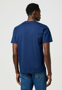 T-shirt a maniche corte blu navy in cotone, con collo tondo e orlo dritto, dalla texture liscia e senza pattern o accenti visibili.