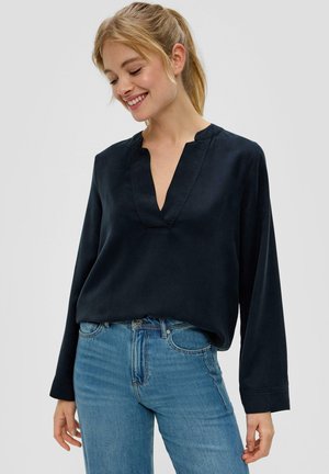 Marineblauw blouse met lange mouwen en V-hals, gemaakt van een gladde stof. Heeft een relaxte pasvorm en subtiele stiksels. G gecombineerd met blauwe jeans.