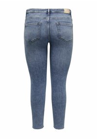 Jeans ajustados en denim azul claro, con una cintura de altura media, diseño de cinco bolsillos y un sutil dobladillo desgastado en los tobillos. Textura suave.