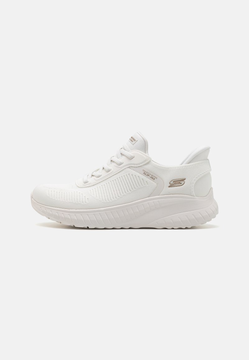 Baskets blanches de sport avec une tige en maille texturée, un col rembourré et une semelle extérieure épaisse et amortie. Présente un branding minimal avec des accents dorés.