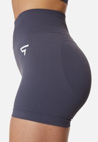 Vysoké, priliehavé tréningové šortky v tmavosivej farbe s hladkým povrchom; na boku sa nachádza biele logo.