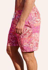 Shorts da nuoto rosa con motivi floreali e paisley ornati, vita elastica e dettaglio con coulisse. Realizzati in tessuto leggero.
