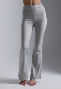 Pantalons de yoga gris évasés en matière extensible, présentant une taille haute froncée et une texture lisse, sans motifs ni accents visibles.