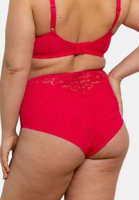 Ensemble de lingerie rose vif comprenant un bralette accentué de dentelle et un slip taille haute, présentant une texture lisse et une coupe ajustée.