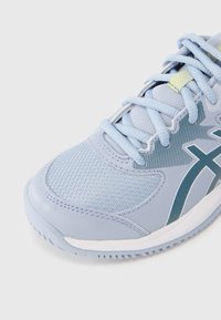 Αθλητικό παπούτσι ανοιχτού μπλε χρώματος με διαπνέον υλικό από δίχτυ, υφή στην επιφάνεια και αντιθετικές σκούρες μπλε λεπτομέρειες με λευκή σόλα.