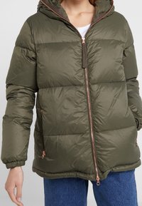 Olivově zelená péřová bunda s kapucí, plným zipem, žebrovanými manžetami a kapsami na zip. Má hladký, lesklý povrch.