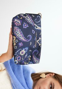 Mornarska kozmetička torbica s mnoštvom floralnih paisley uzoraka u raznim bojama, s zlatnim patentnim zatvaračem i malim logotipom. Glatka tkanina s čvrstim oblikom.