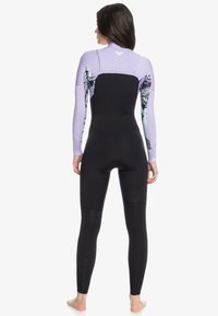 Neopreno de manga larga, con parte superior morada y cuerpo negro, que presenta un patrón floral en las mangas, textura suave y diseño ajustado para deportes acuáticos.