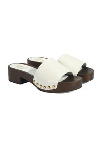 Witte gepatenteerde leren sandalen met blokhak, voorzien van een brede band en gouden studs langs de rand. De houten basis voegt contrast toe aan het ontwerp.