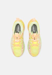 Lehké, síťované běžecké boty v jasně žluté barvě s růžovými akcenty, s texturovaným svrškem, měkkou stélkou a šněrováním.