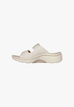 Cream-colored slide sandal with a textured fabric upper, open toe, and dual strap design. Features a molded, lightweight sole.