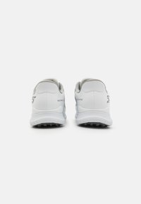 Baskets de sport blanches avec une tige synthétique lisse, des accents gris, des talons rembourrés et des semelles extérieures en caoutchouc texturé pour une meilleure adhérence.