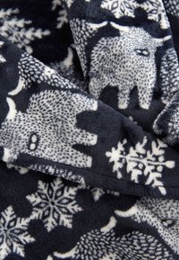 Granatowy koc z polaru z fakturą białych słoni i wzorów płatków śniegu. Miękki, ciepły materiał o gładkim wykończeniu i nakładających się warstwach.