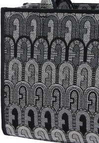 Szara i czarna torba typu tote z geometrycznym, łukowatym wzorem, wykonana z textured materiału, z mocnym czarnym wykończeniem i dwiema górnymi rączkami.