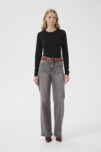 Svart topp med lange ermer kombinert med høytlivs, vidbente grå jeans. Brunt belte med en rektangulær spenne; glatt stofftekstur.