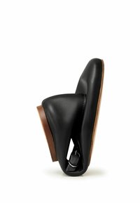 Svart lädersko med en slimmad design, med en böjd form och en träsole. Inkluderar en synlig metalldetalj på hälen.