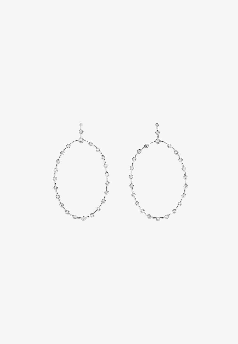 Srebrne owalne kolczyki w kształcie obręczy z łańcuchowym wzorem, w którym równomiernie rozmieszczone są okrągłe, przezroczyste kamienie.