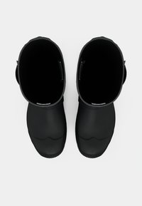 Bottes en caoutchouc noires avec une finition lisse et mate. Elles ont des ouvertures larges et des orteils arrondis, avec une semelle texturée pour une meilleure adhérence.