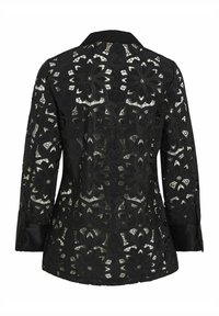 Blouse en dentelle noire ornée de motifs floraux, au design ajouré, avec des manches longues et des poignets noirs unis. Col classique et coupe ajustée.