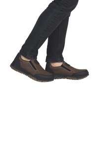 Braune Wildleder- und schwarze synthetische Slipper mit Gummisohlen, ausgestattet mit elastischen Seitenpaneelen und kontrastierenden Nahtdetails.