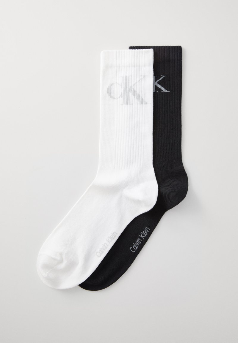 Calvin Klein sokker, en hvid og en sort, ribbet tekstur, med logo i grå. Bløde, mellemhøje, i kontrastfarver.