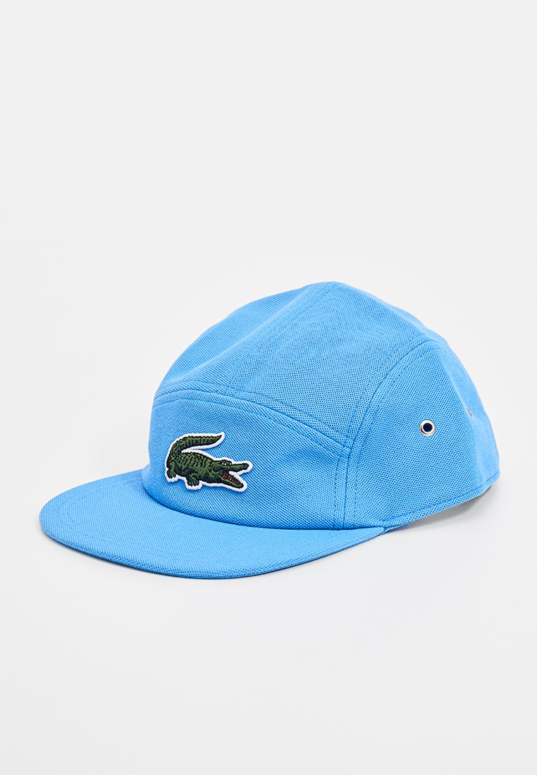 Blauwe baseballpet van gestructureerde stof, met een groene geborduurde krokodillogo aan de voorkant en een platte klep.