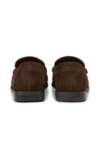 Braune Wildleder Slipper mit niedrigem, flachem Absatz, runder Zehenform und minimalen Nähdetails auf der Rückseite. Glatte Lederlaufsohle für Langlebigkeit.