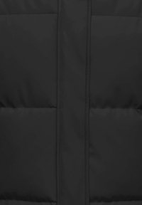 Crna prozračna jakna s elegantnim dizajnom, prošivenom teksturom i centralnim zatvaračem na patent. Glatki materijal s minimalnim detaljima od hardvera.