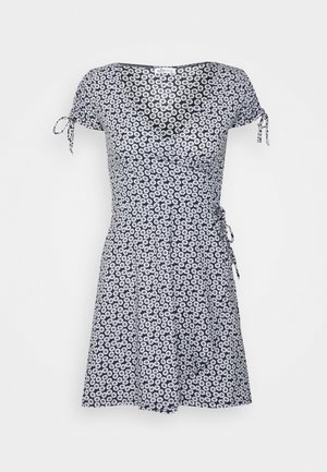 Zwart-witte bloemen wikkeljurk met korte mouwen, strikdetails op de schouders en een uitlopende rok die boven de knie valt.