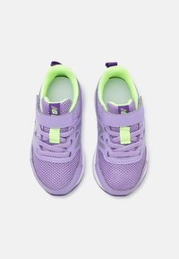 Chaussures d'enfants violettes en tissu en maille, avec des accents verts, une sangle ajustable, des lacets et une semelle en caoutchouc blanche. Présente un petit logo sur la sangle.