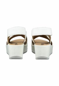 Sandali platform bianchi con un retro aperto, una fascia larga sulla punta e una soletta imbottita. Realizzati in materiale sintetico liscio.