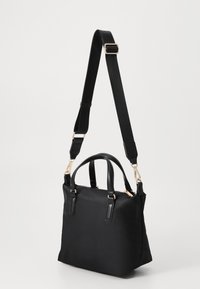 Borsa nera con un design strutturato, caratterizzata da un tessuto testurizzato, manici doppi e una tracolla rimovibile con dettagli in metallo dorato.
