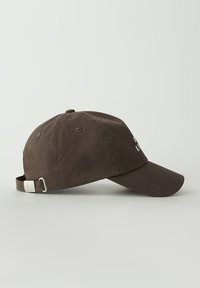 Brącapka baseballowa z brązowej bawełny, z zaokrągloną koroną, zakrzywionym daszkiem i regulowanym paskiem z metalową klamrą z tyłu. Prosty design.