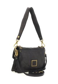 Borsa a tracolla in pelle nera con borchie dorate, tracolla regolabile e manico largo, mostrata su uno sfondo bianco.