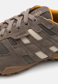 Baskets en daim marron et mesh avec accents gris, lacets ronds et semelle en caoutchouc gomme. Présentent un logo et trois bandes latérales.