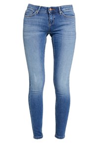Jeans ajustados de denim azul claro con efecto desgastado, cinco bolsillos, cierre de botón metálico y costuras en contraste. Sin marcas visibles.