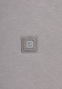Graues Strickgewebe mit einem quadratischen, strukturierten Patch, der das eingeprägte Logo "GABBIANO" trägt. Der Patch hat einen umgebenden, gestickten Rand.