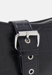 Borsa in finta pelle nera a coste di coccodrillo con hardware in tono argento, dotata di una tracolla con fibbia e chiusura a zip nella parte superiore.