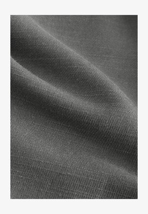 Pelēks teksturēts audums ar smalku aušanu, izskatās mīksts un gluds ar niansētām krāsu un gaismas atspīdēšanas variācijām, bez skaidriem rakstiem.