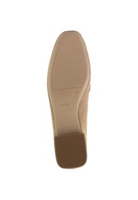 Beige mockasinhåll med lätt klack. Platt, rund tås design har en strukturerad botten för grepp. Logotyp tryckt nära klacken.
