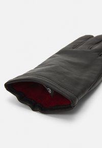 Guanto in pelle nera con una texture liscia e foderato in pile rosso. Presenta cuciture lungo le dita e un'apertura del polsino delicatamente curva.