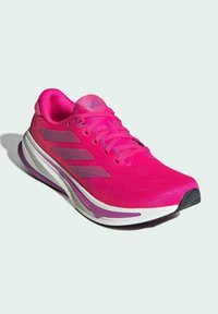 Baskets de sport roses en maille respirante avec des accents synthétiques. Comprend des détails violets, un système de laçage et une semelle blanche rembourrée.