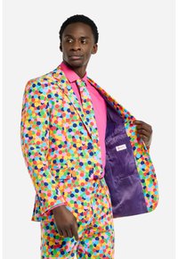Completo a pois colorati con cerchi vivaci in rosa, verde, blu e giallo. Presenta una camicia rosa e un rivestimento interno viola.