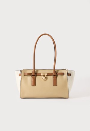 Sac à main rectangulaire beige avec poignées et détails marron, panneaux latéraux blancs et un fermoir circulaire doré à l'avant.