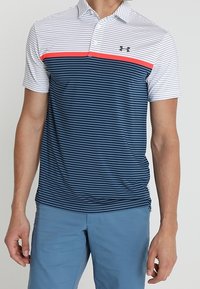 Miestenská polokošeľa s bielymi a námorníckymi horizontálnymi pruhmi, červeným akcentovým pásom, golierovým dizajnom a logom Under Armour na hrudi. Mäkšia látka.