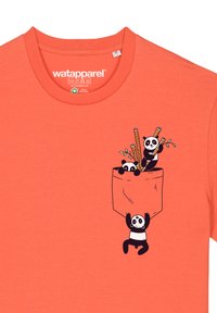 Korallfarbenes T-Shirt aus Bio-Baumwolle mit einem Taschendesign, das schwarz-weiße Pandas zeigt, die Bambusstangen und Blätter halten.