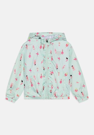 Veste enfant bleu clair à capuche avec fermeture éclair devant et motifs roses sur le thème de la plage comprenant des nageurs, des planches de surf et des bouées.